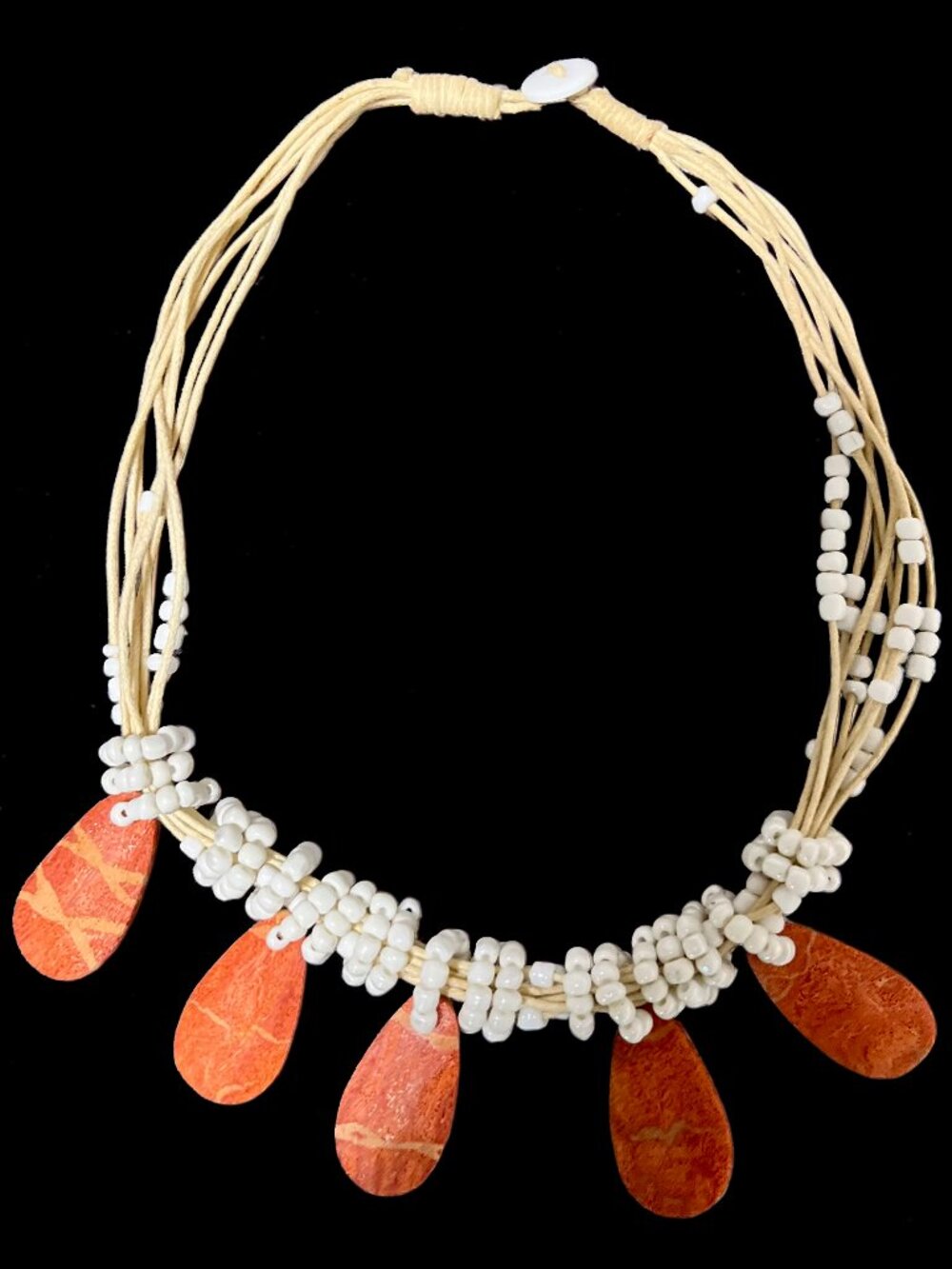 Coral-colored teardrop pendant and white beaded necklace